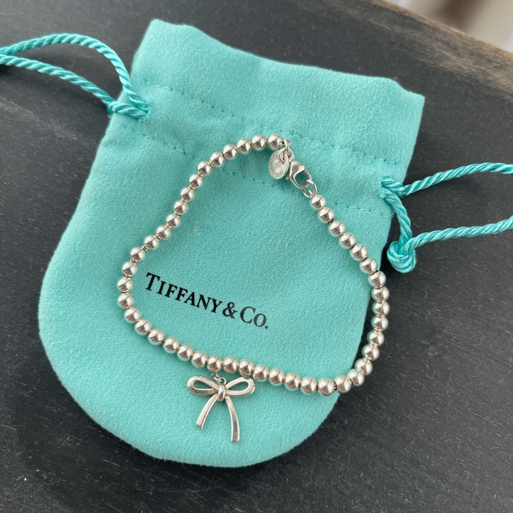 Tiffany & Co silver beaded bracelet, bow pendant. Includes original pouch.